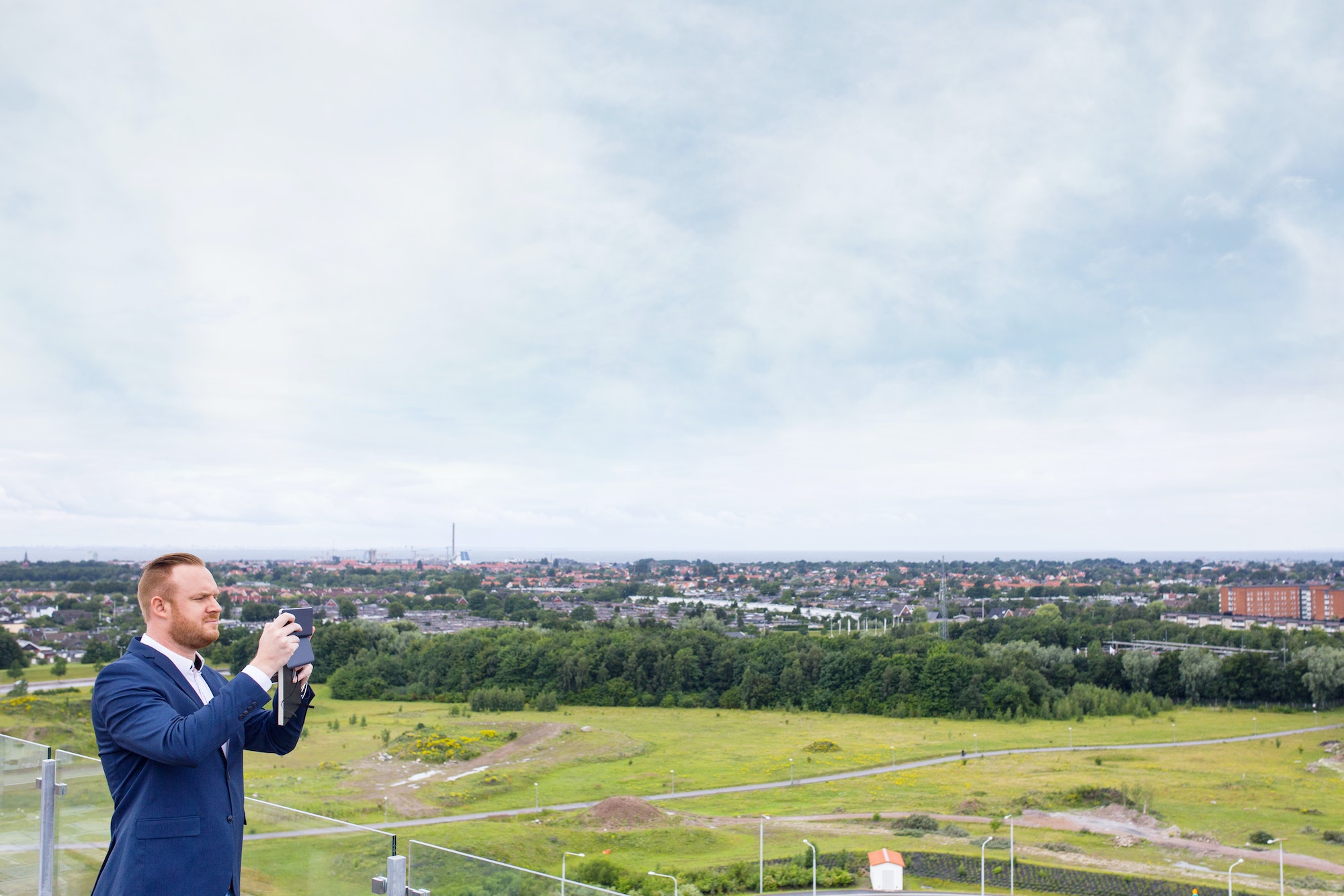 Architect on rooftop photographing through smart phone